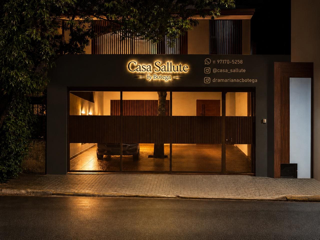 Fachada iluminada da Casa Sallute by Botega à noite, em São Paulo